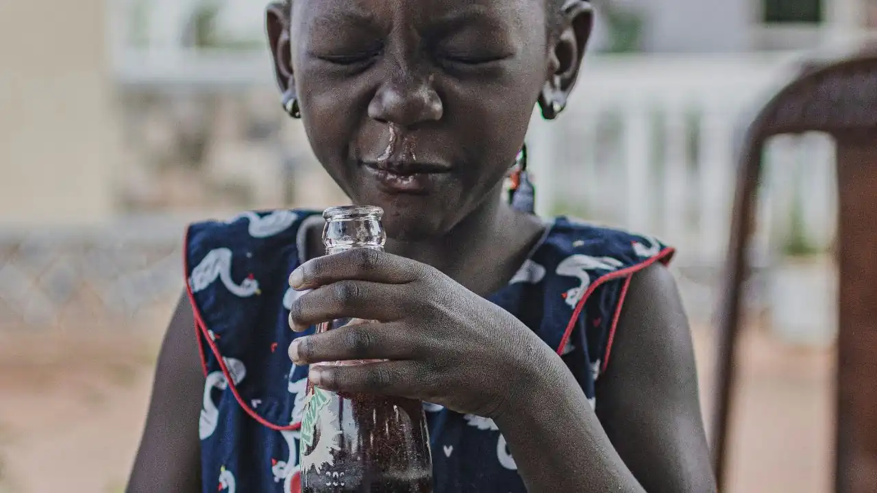A picture showing a girl with mucus dripping from her nose.