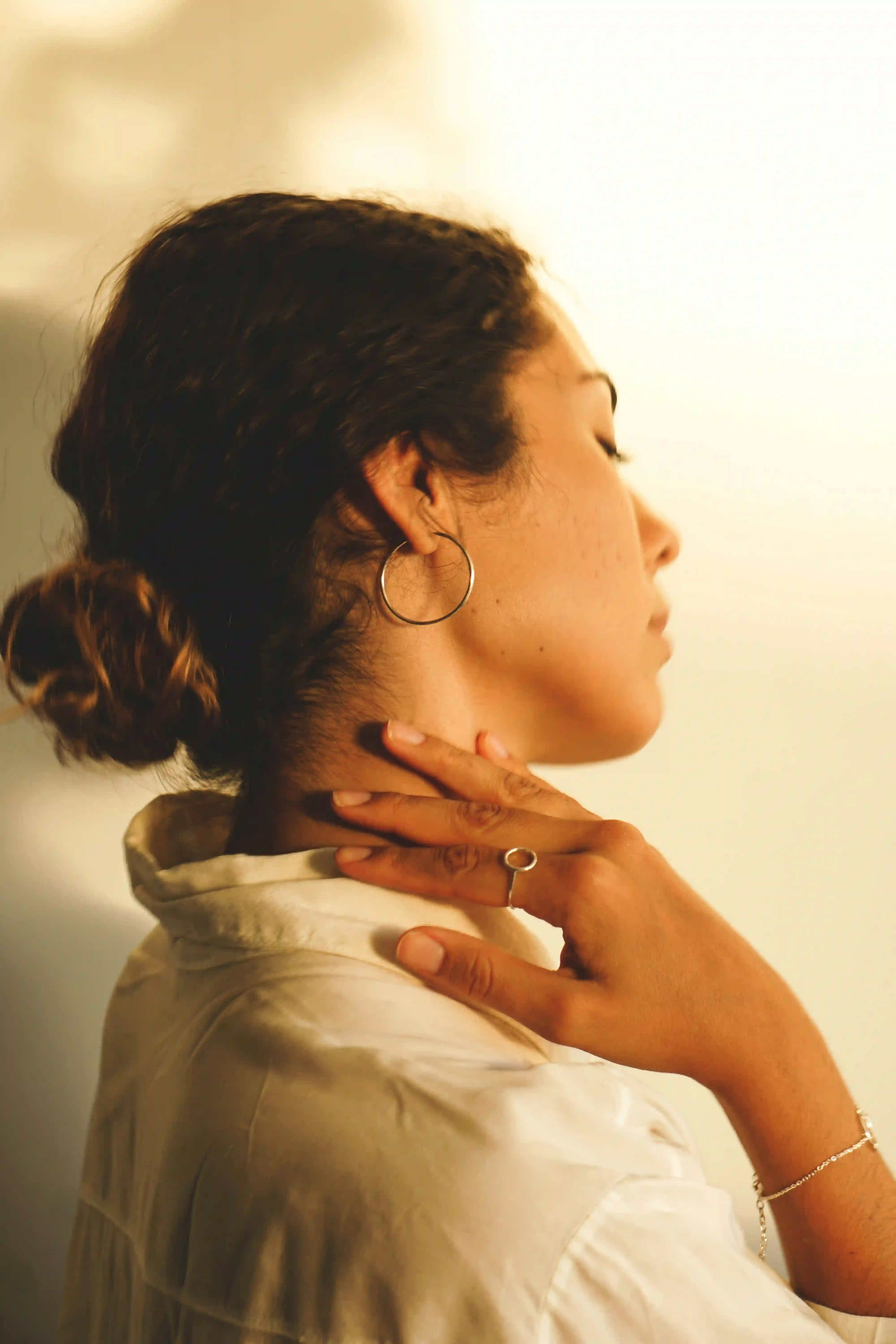 A picture showing a woman holding her neck in pain.