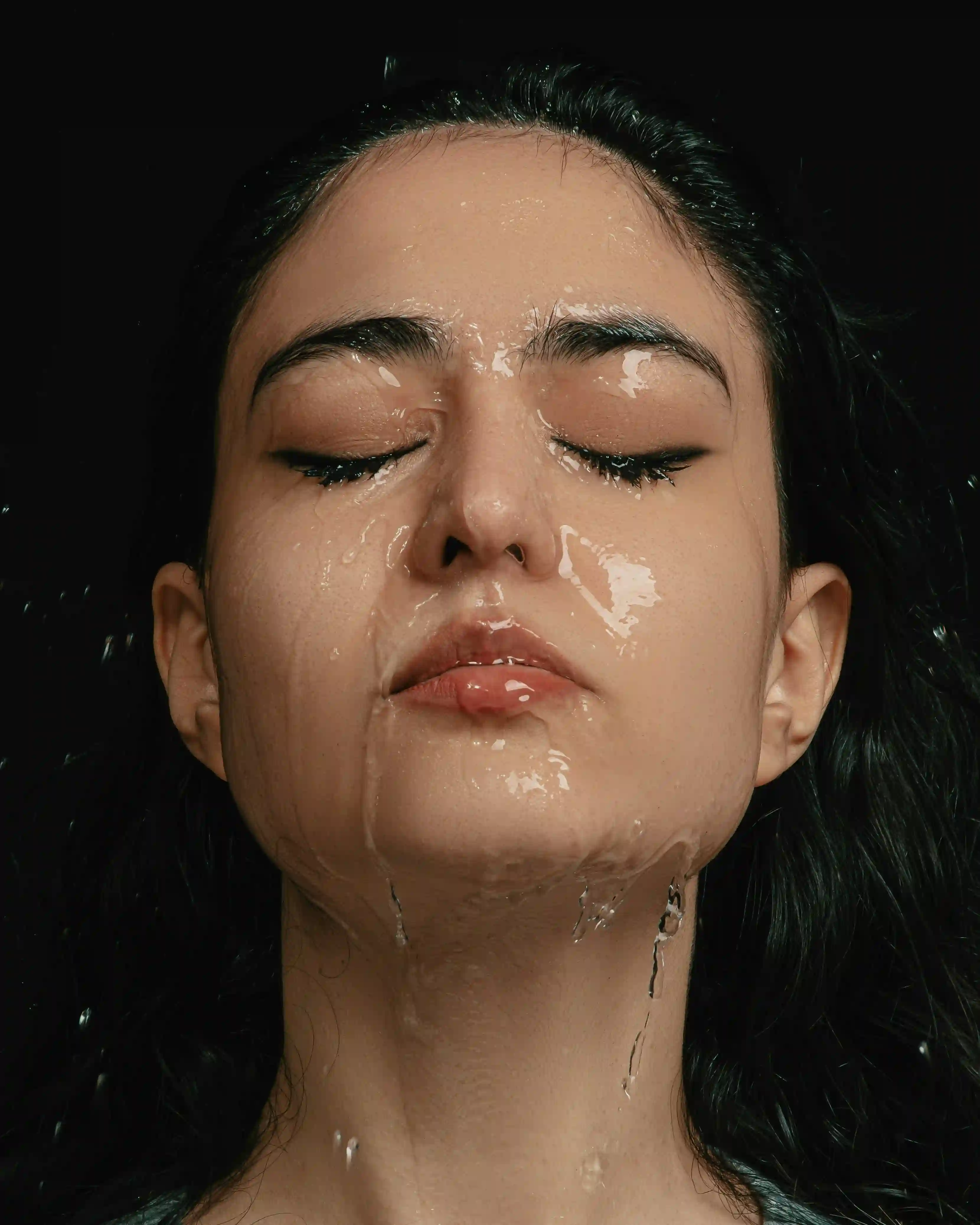 A picture showing a woman washing her face.